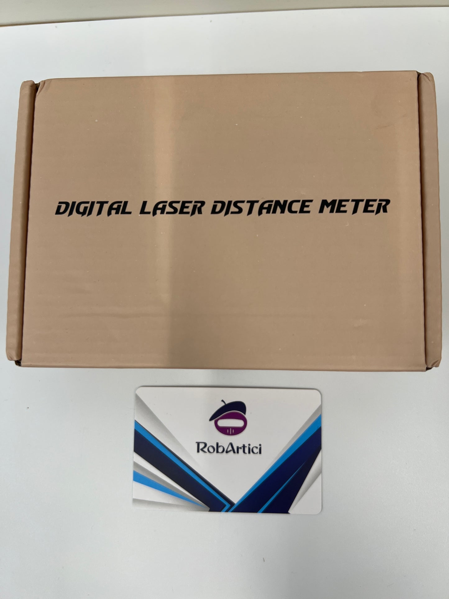 E-100 portable digital laser distance meter retail packaging, front view.