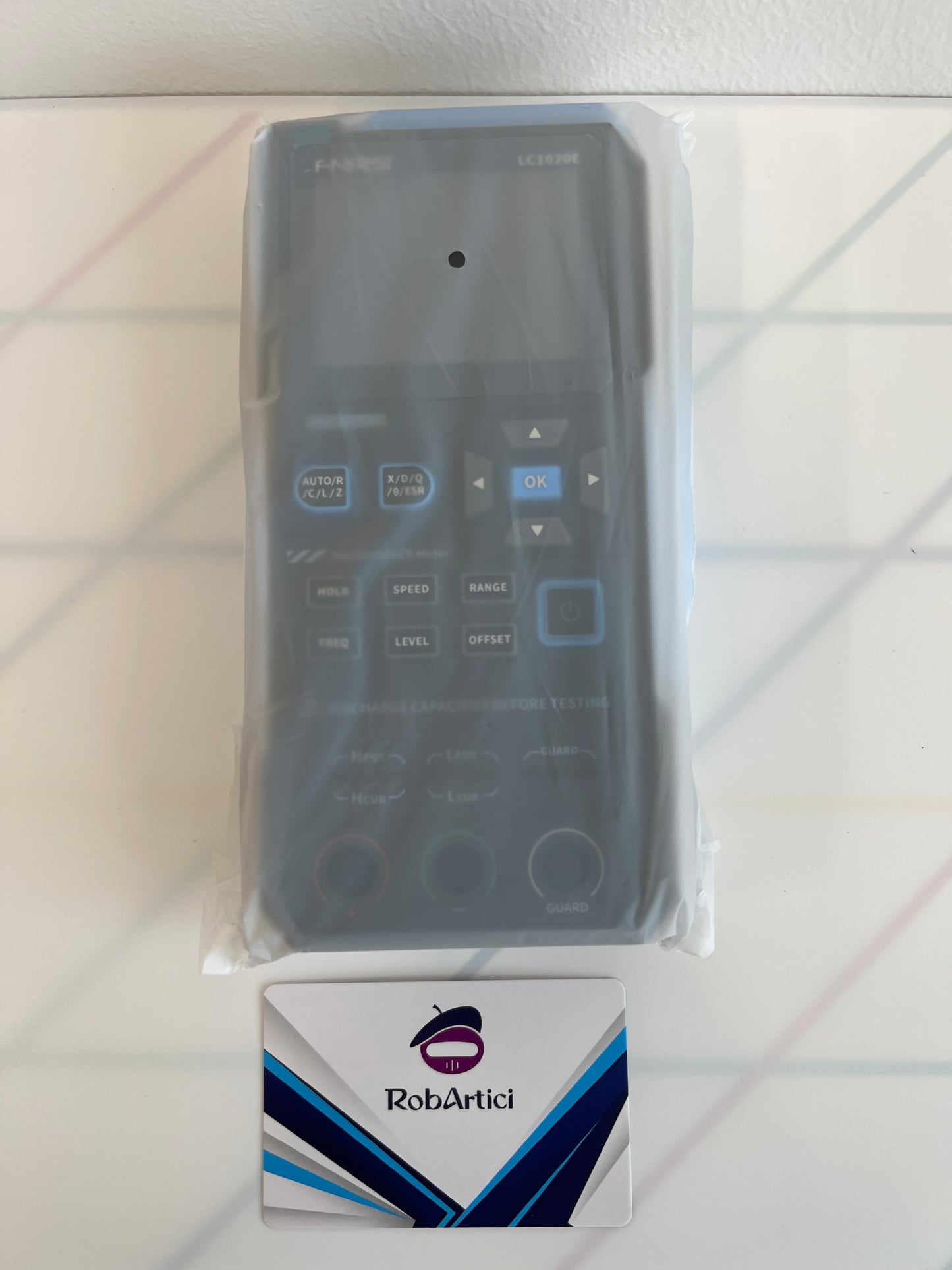 FNIRSI LC1020E handheld LCR meter front view showing the digital display monitor and control buttons