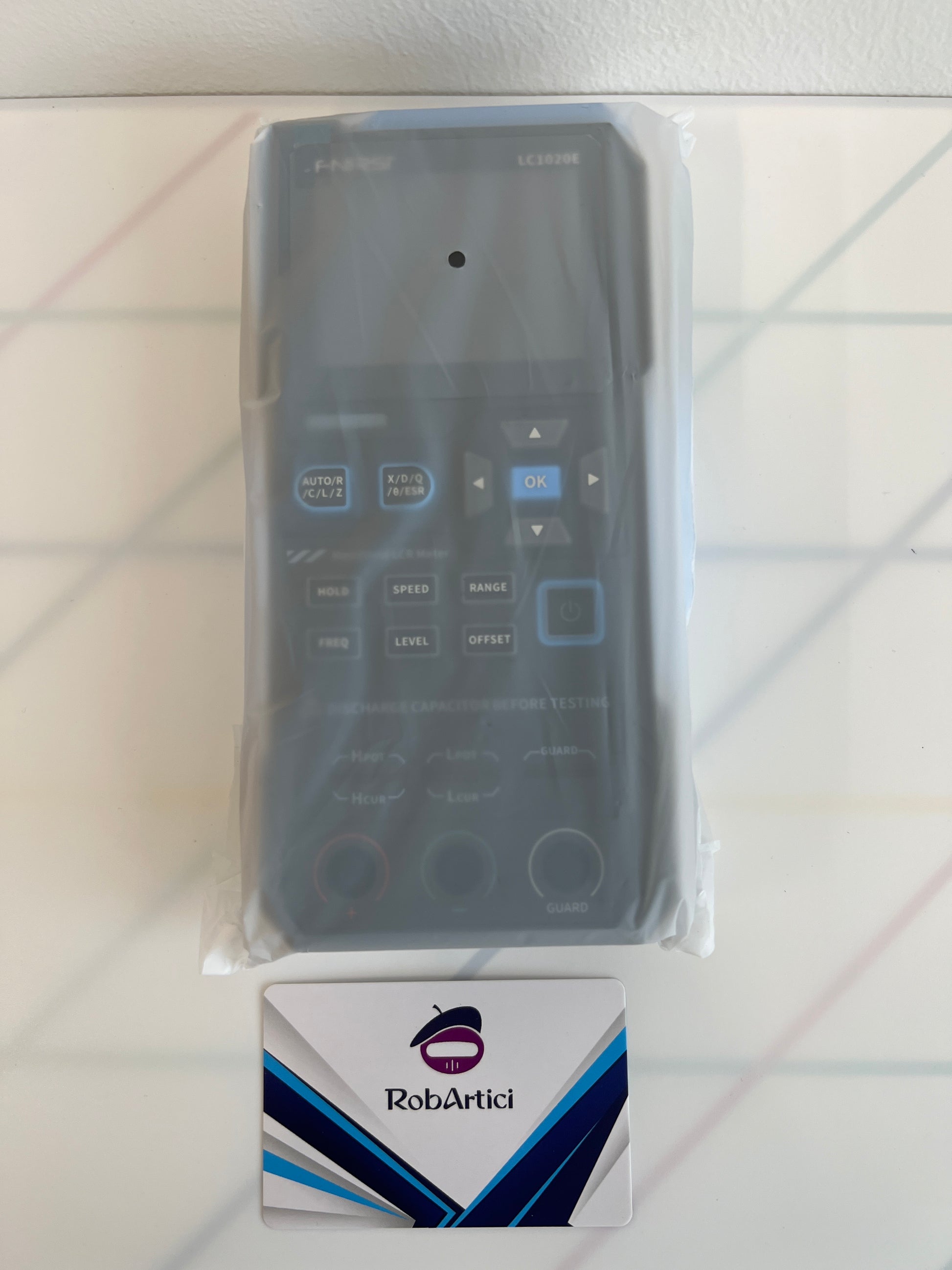 FNIRSI LC1020E handheld LCR meter front view showing the digital display monitor and control buttons